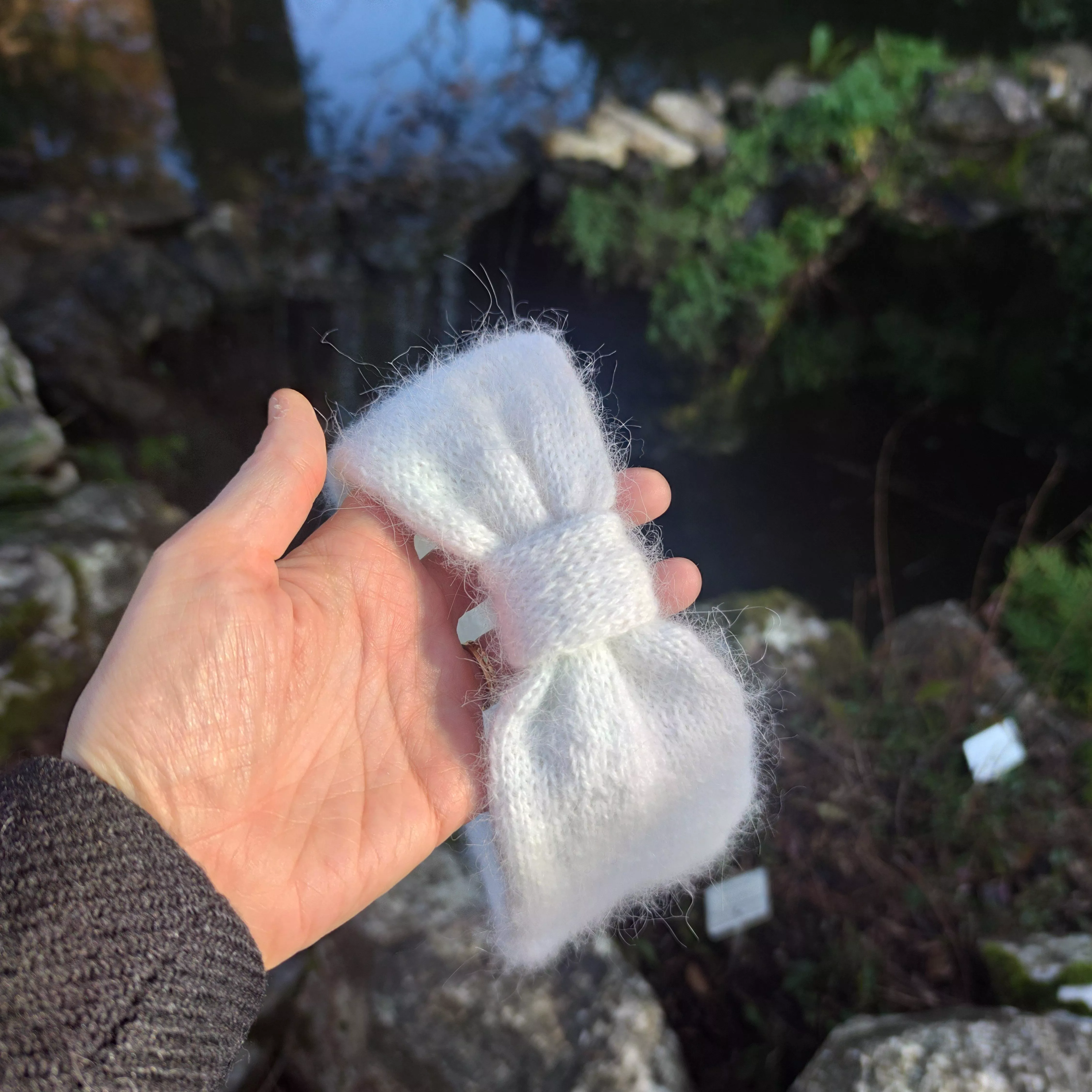 Headband tenu dans une main sur fond de foret 